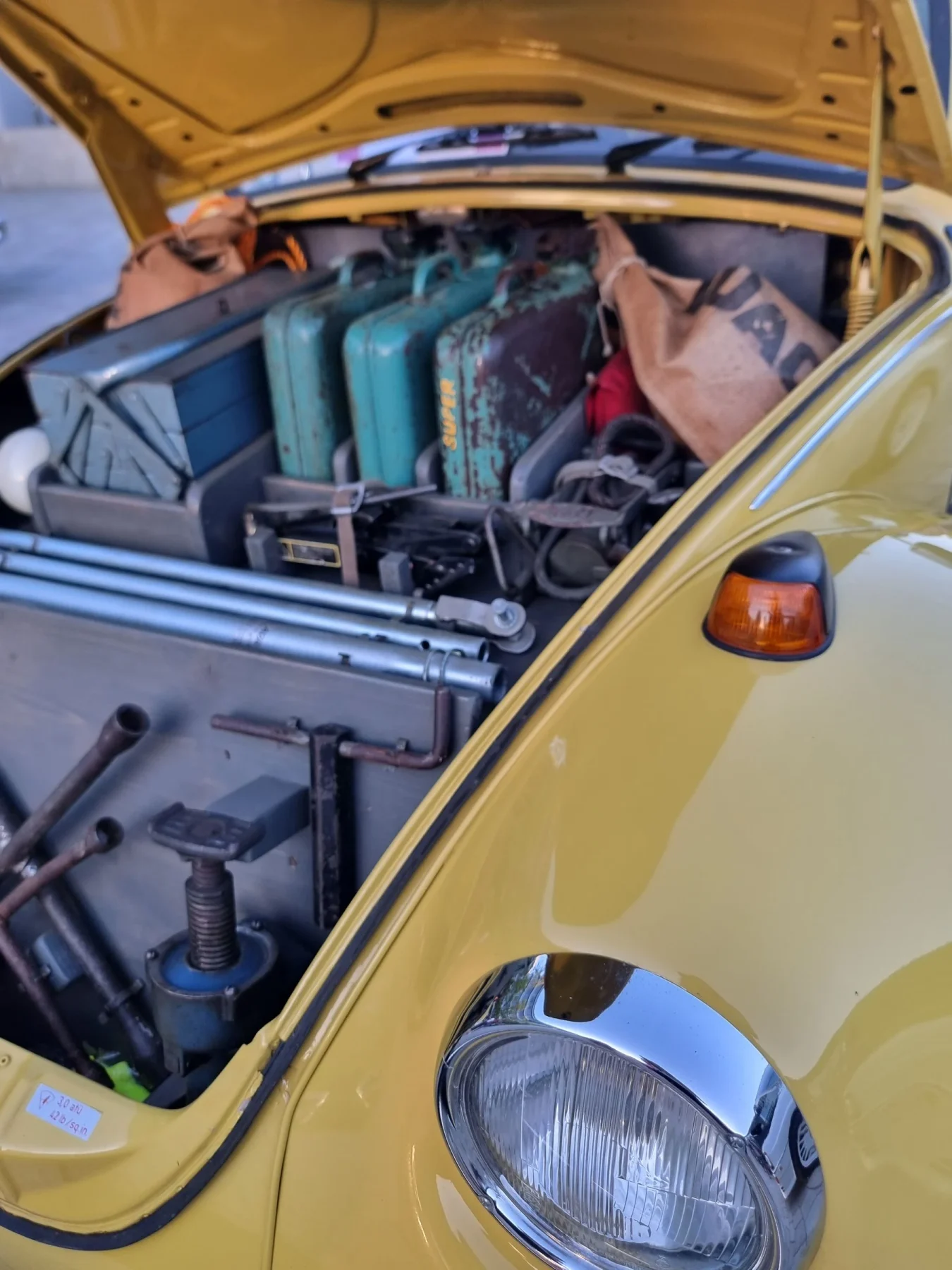 Bagagem na mala dianteira aberta de um automóvel clássico amarelo